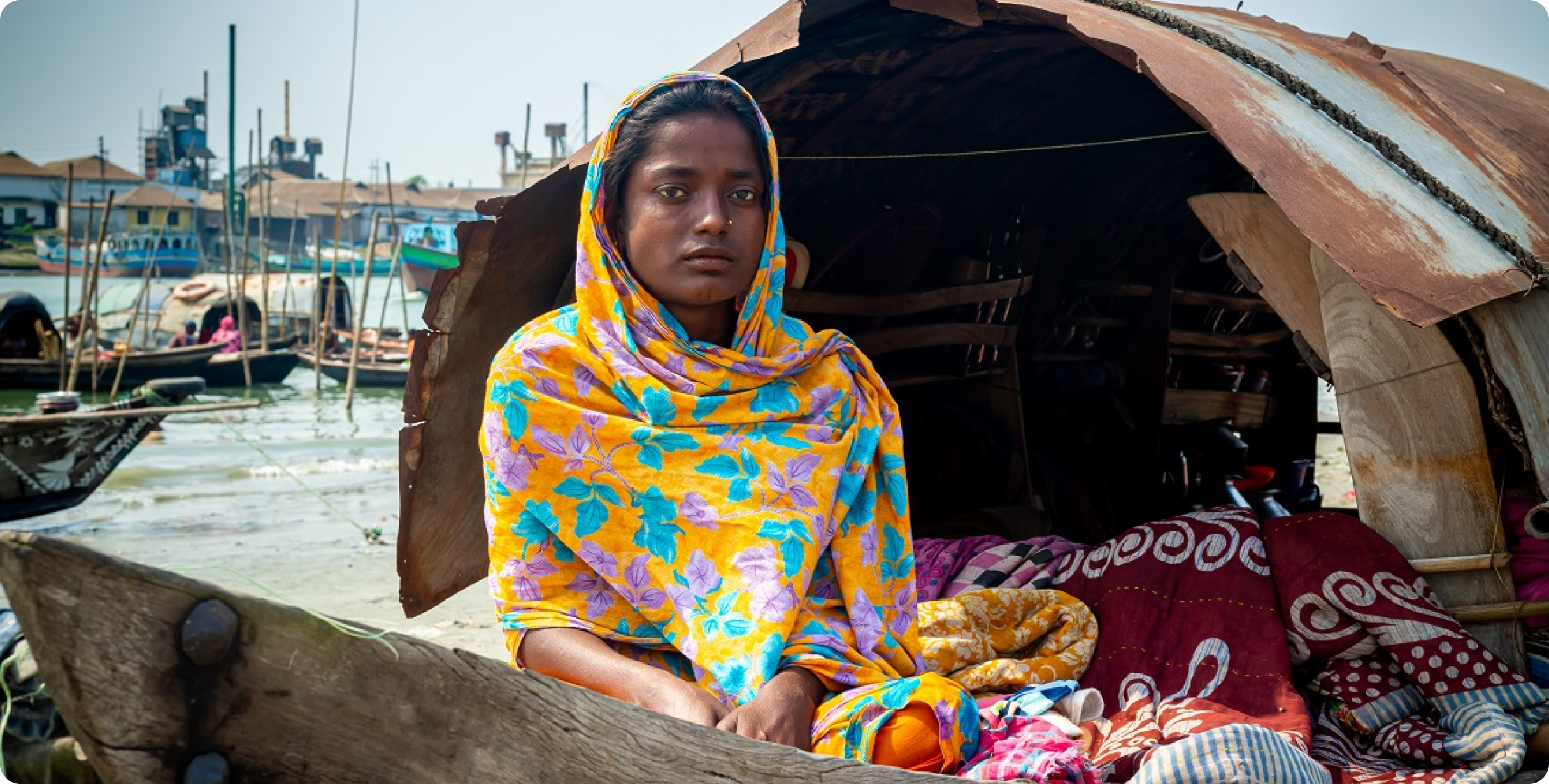 정면을 응시하는 방글라데시 배 위의 여성 거주민